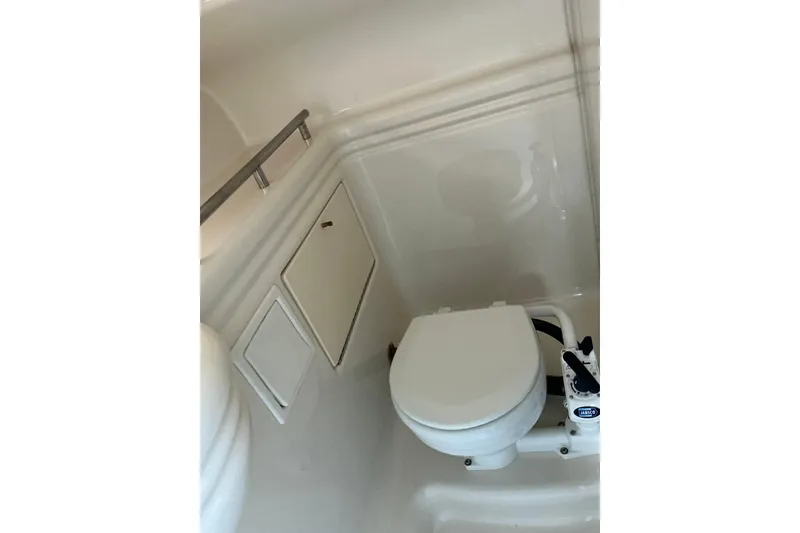 Slide: The Image of 1997 Maxum 2700 SCR boat bathroom with compact marine toilet and storage compartments. - 20