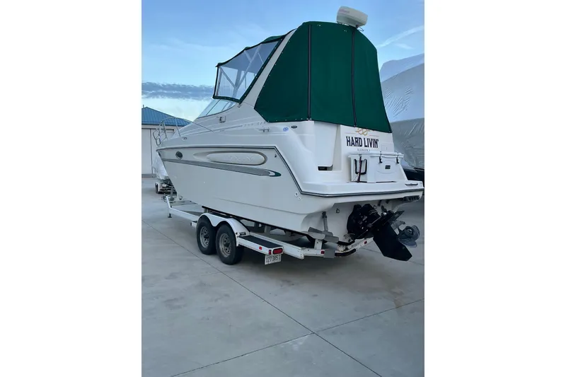 Slide: The Image of 1997 Maxum 2700 SCR boat on trailer with green canopy, parked outdoors. - 3