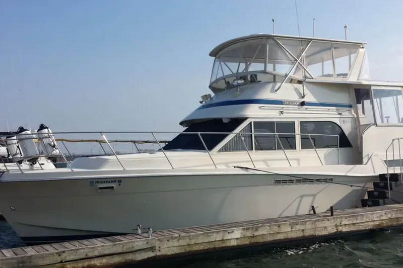 The Image of 1987 Chris-Craft 427 Catalina yacht docked at a marina under clear skies. - 1