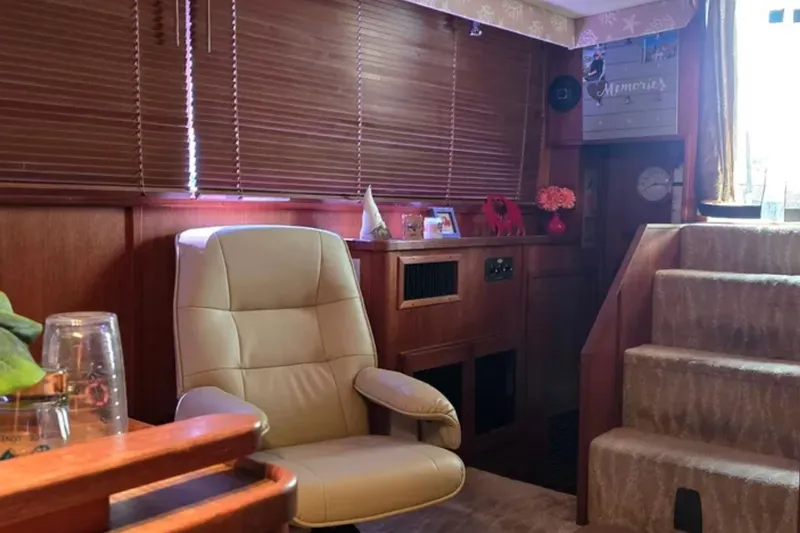Slide: The Image of Interior of 1987 Chris-Craft 427 Catalina yacht with beige chair and wooden accents. - 10