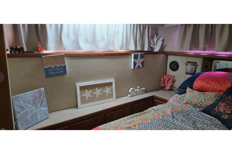 Slide: The Image of Cozy interior of 1987 Chris-Craft 427 Catalina with nautical decor and colorful bedding. - 13