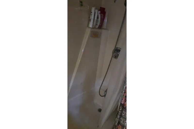 Slide: The Image of Shower area inside 1987 Chris-Craft 427 Catalina boat with toiletries and curtain. - 15