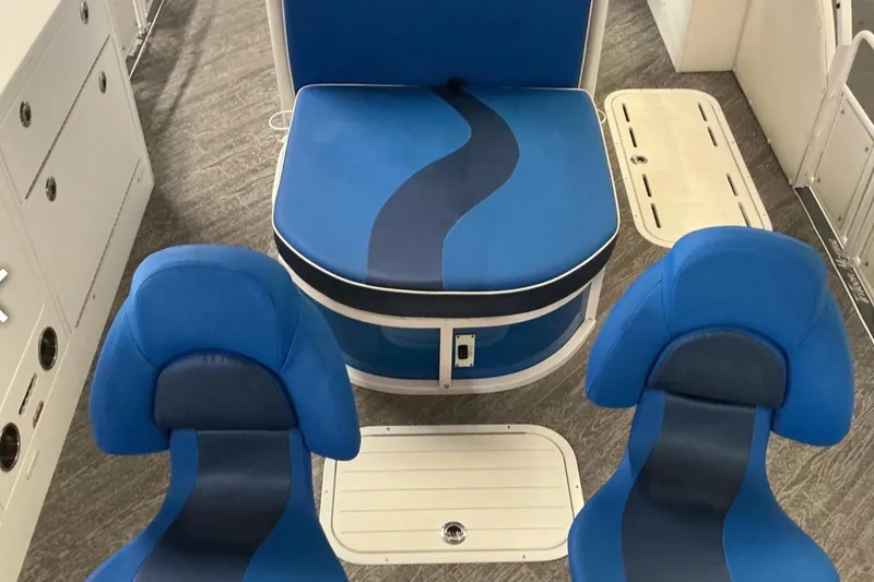 Slide: The Image of Interior of 2025 JC SportAngler 26TT HTH boat with blue seating and storage compartments. - 14