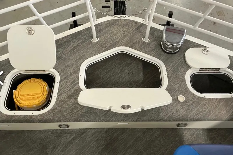 Slide: The Image of 2025 JC SportAngler 26TT HTH boat deck with storage compartments and safety equipment. - 17