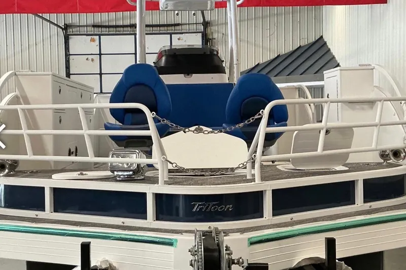 Slide: The Image of 2025 JC SportAngler 26TT HTH boat with blue seating and railing in a warehouse. - 8