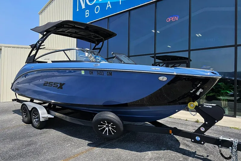 Slide: The Image of 2023 Yamaha Boats 255XD in blue on trailer outside dealership. - 12