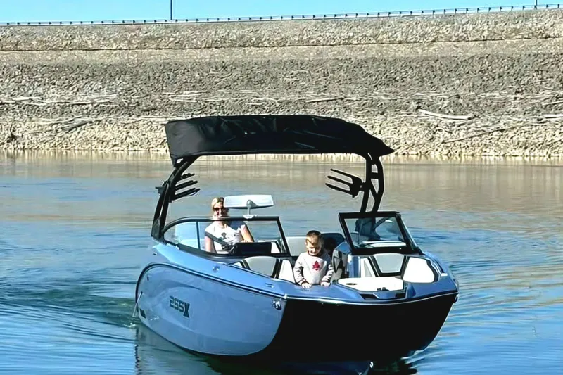 Slide: The Image of 2023 Yamaha Boats 255XD on calm water with passengers, featuring sleek design and modern amenities. - 14