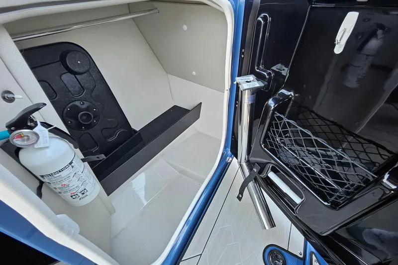 Slide: The Image of Interior storage compartment of 2023 Yamaha Boats 255XD with fire extinguisher and netted pocket. - 20