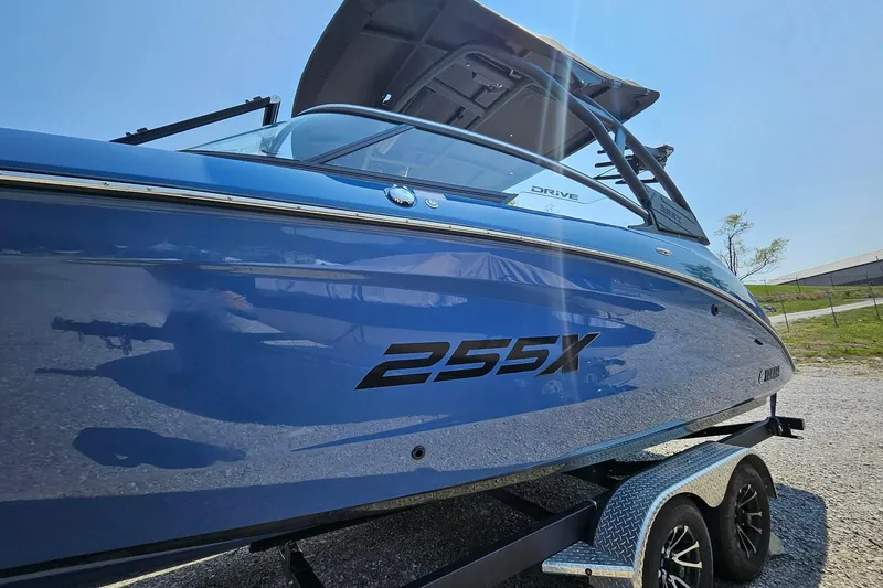 Slide: The Image of 2023 Yamaha Boats 255XD in blue on a trailer, side view. - 21