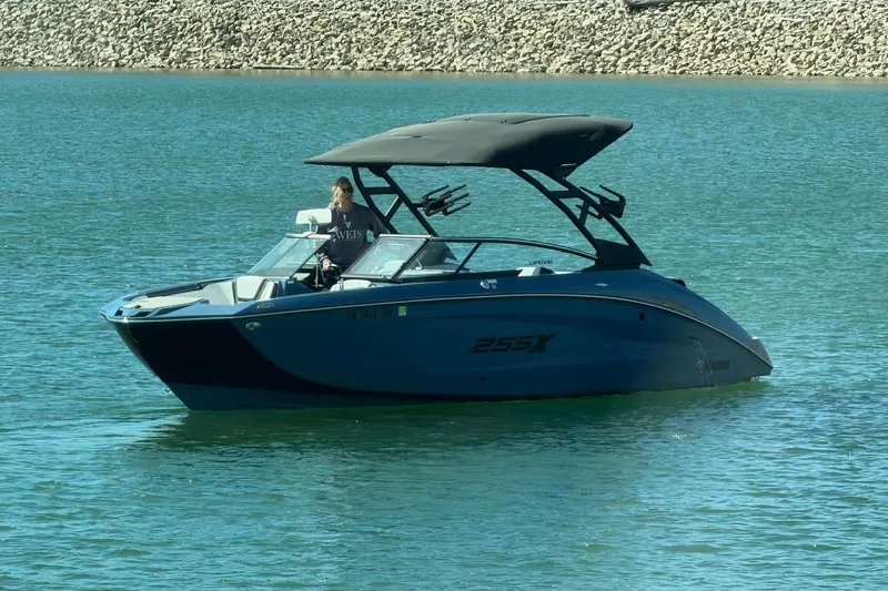 Slide: The Image of 2023 Yamaha Boats 255XD on calm water with a person at the helm. - 24