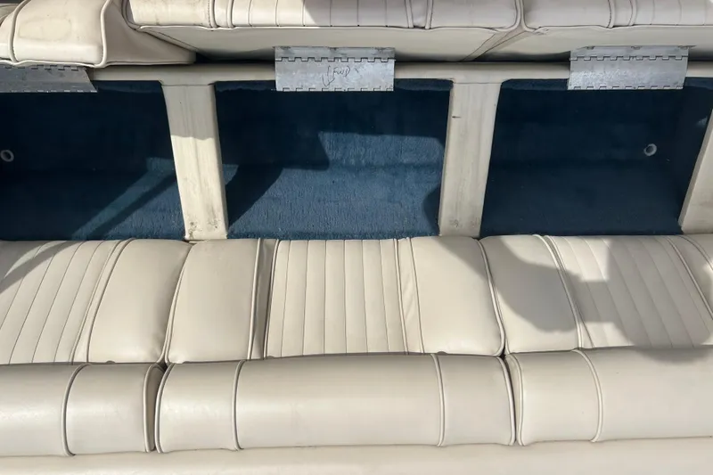 Slide: The Image of Interior seating of a 1996 Mariah 180 Shabah boat with white upholstery and storage compartments. - 17