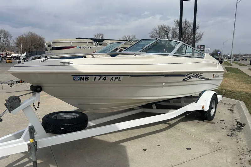 Slide: The Image of 1996 Mariah 180 Shabah boat on trailer, parked outdoors on a cloudy day. - 2