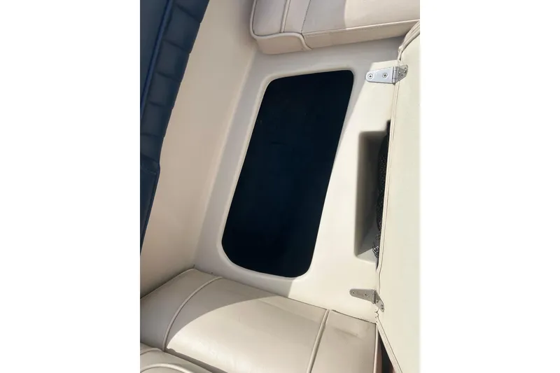 Slide: The Image of Interior view of a 1996 Mariah 180 Shabah boat, featuring beige seating and storage compartment. - 22