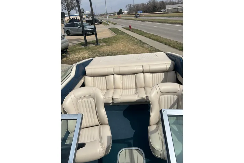 Slide: The Image of Interior of a 1996 Mariah 180 Shabah boat with beige seating and blue flooring. - 25