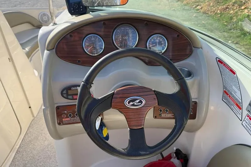 Slide: The Image of Steering wheel and dashboard of a 2005 Sea Ray 220 Sundeck boat. - 10