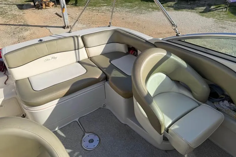 Slide: The Image of 2005 Sea Ray 220 Sundeck interior with beige seating and carpeted floor. - 12