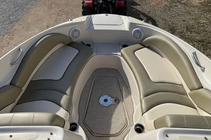 Slide: The Image of 2005 Sea Ray 220 Sundeck boat interior with beige seating and carpeted floor. - 13