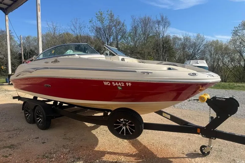 Slide: The Image of 2005 Sea Ray 220 Sundeck boat on trailer, red and white exterior, parked outdoors. - 3