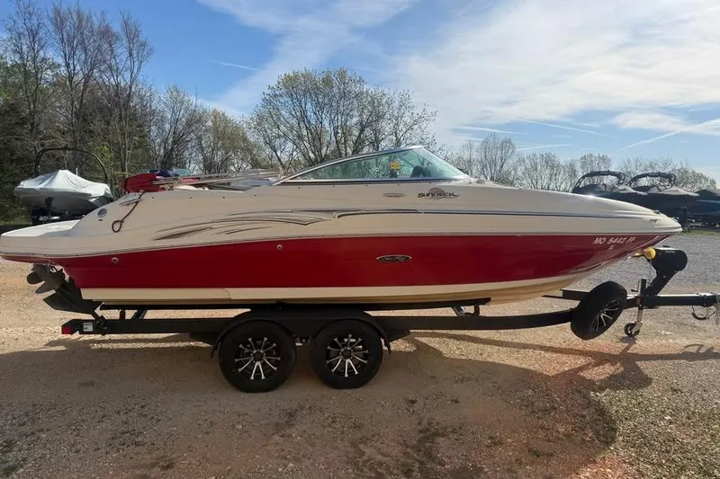 Slide: The Image of 2005 Sea Ray 220 Sundeck boat on trailer, red and white design, parked outdoors. - 4