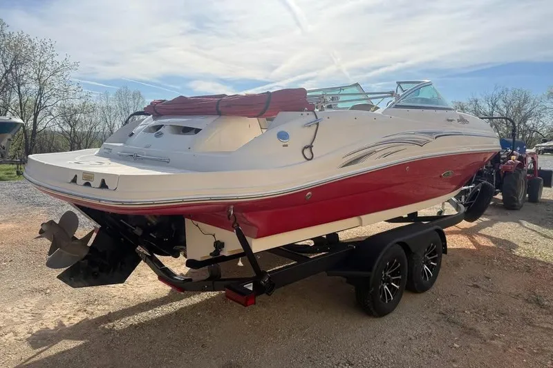 Slide: The Image of 2005 Sea Ray 220 Sundeck boat on trailer, red and white design, parked outdoors. - 5