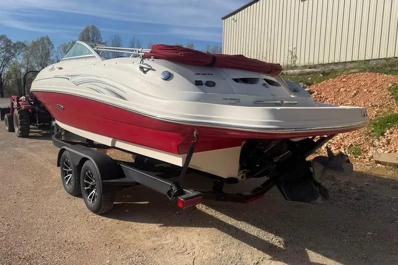 Slide: The Image of 2005 Sea Ray 220 Sundeck boat on trailer, red and white design, parked outdoors. - 7