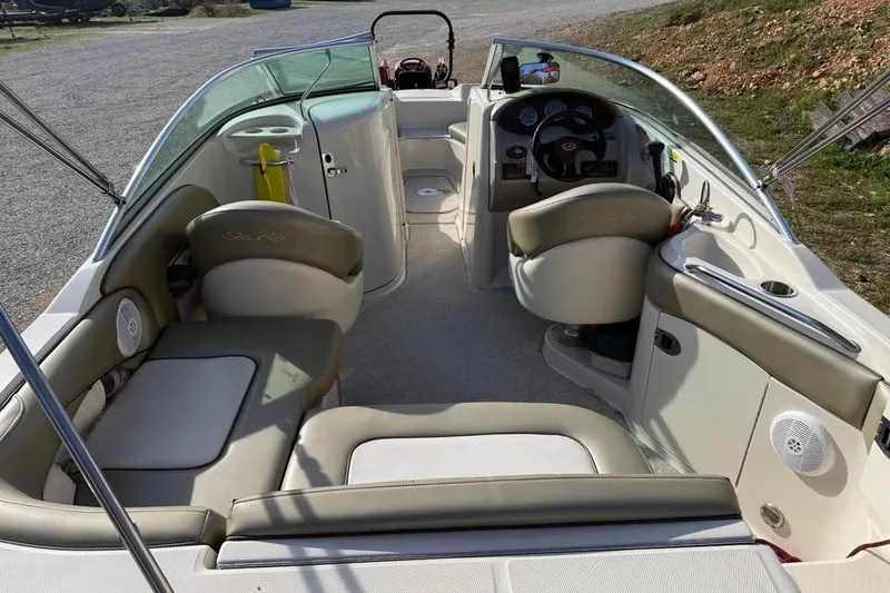 Slide: The Image of 2005 Sea Ray 220 Sundeck interior with beige seating and steering console. - 8