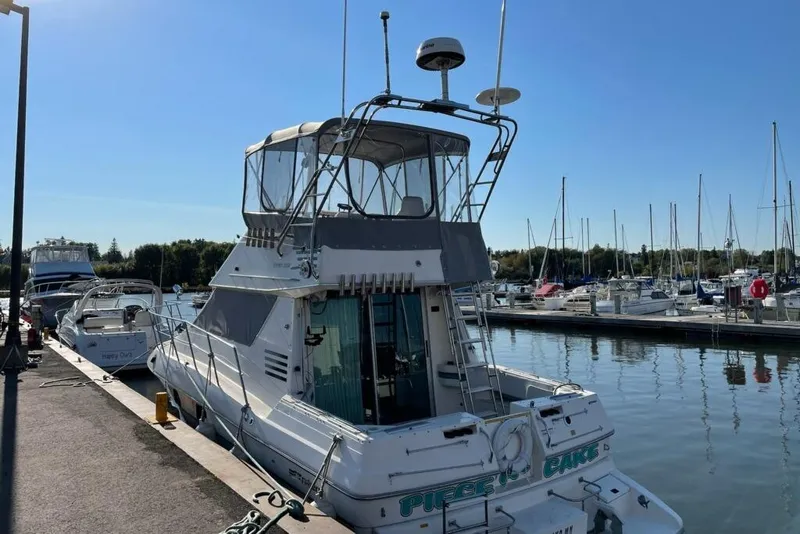 The Image of 1994 Cruisers Yachts 3380 Esprit docked at a marina under clear blue skies. - 0