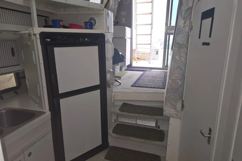 Slide: The Image of Interior of 1994 Cruisers Yachts 3380 Esprit, featuring compact kitchen and steps to deck. - 12