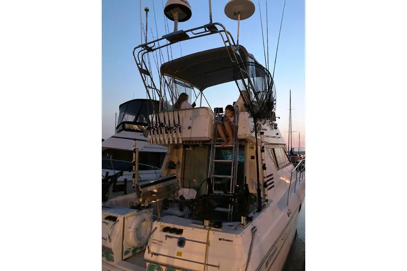 Slide: The Image of 1994 Cruisers Yachts 3380 Esprit docked at sunset with fishing gear. - 3