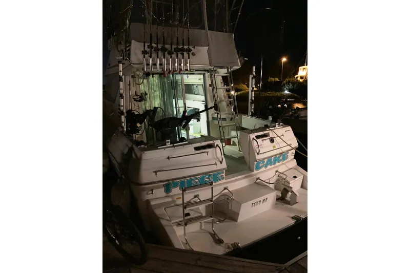 Slide: The Image of 1994 Cruisers Yachts 3380 Esprit docked at night, equipped with fishing gear. - 4
