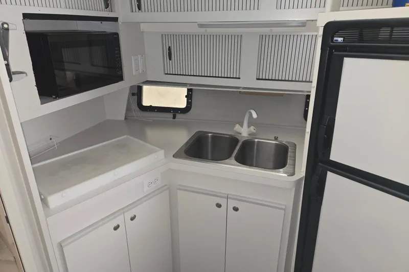 Slide: The Image of 1994 Cruisers Yachts 3380 Esprit kitchen with dual sinks, microwave, and refrigerator. - 9