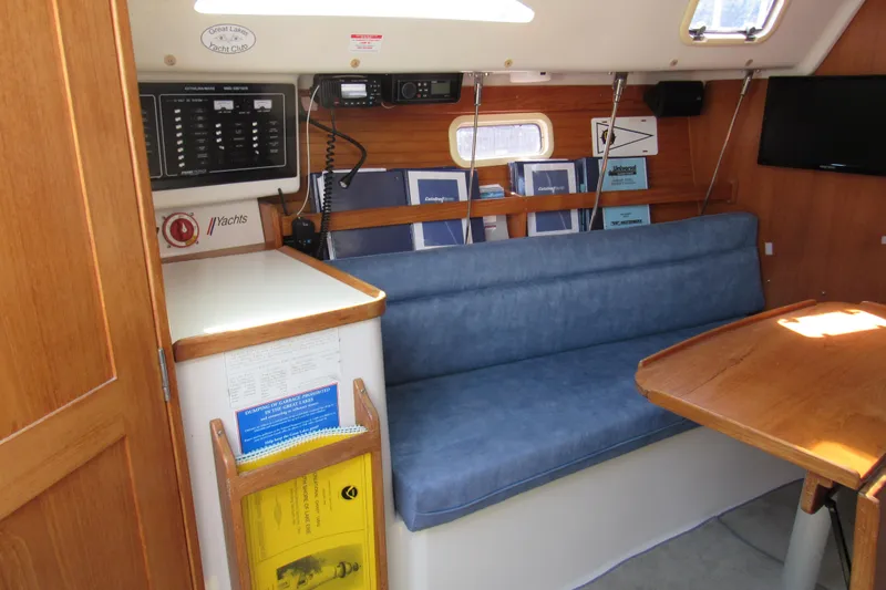 Slide: The Image of Interior of a 1997 Catalina 28 MkII sailboat with blue seating and wooden table. - 12