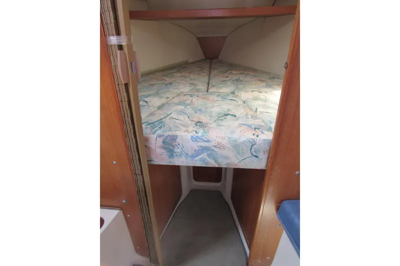 Slide: The Image of 1997 Catalina 28 MkII sailboat interior with V-berth and patterned bedding. - 14