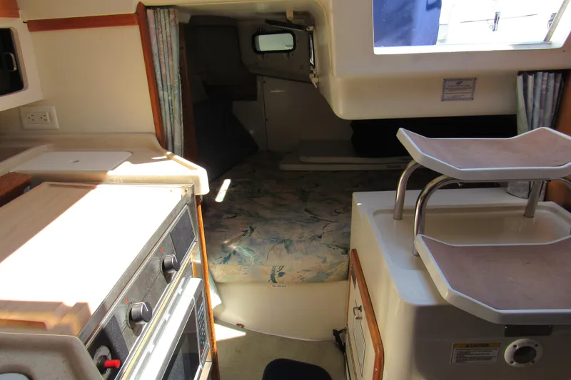 Slide: The Image of Interior of a 1997 Catalina 28 MkII sailboat featuring a compact kitchen and cozy sleeping area. - 16