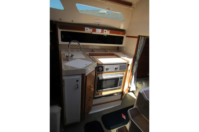 Slide: The Image of 1997 Catalina 28 MkII yacht kitchen with sink, stove, and storage cabinets. - 18