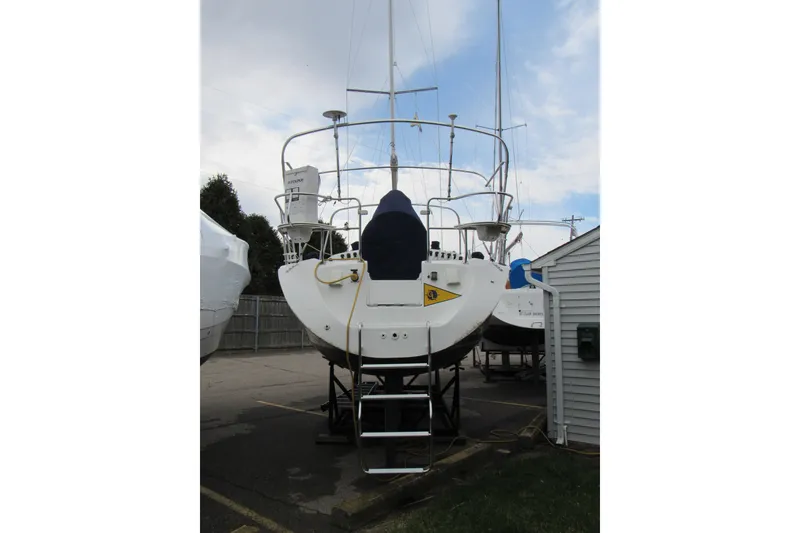 Slide: The Image of 1997 Catalina 28 MkII sailboat on dry dock, rear view with ladder and equipment. - 2