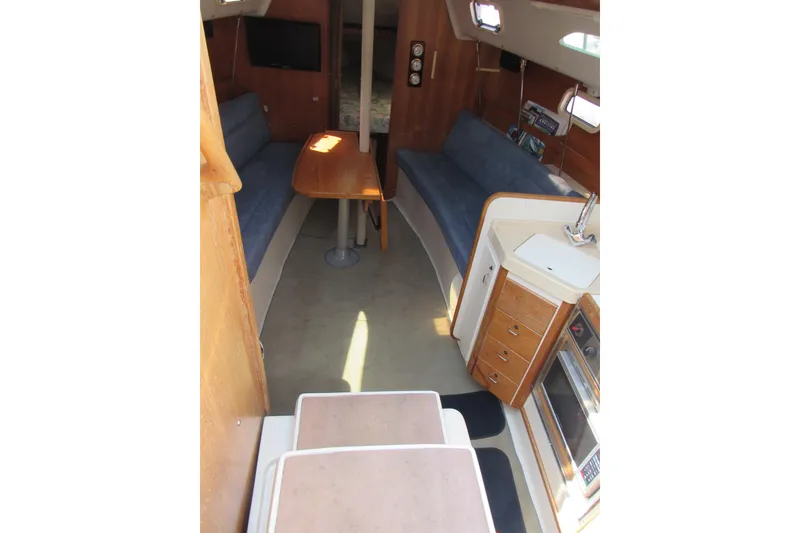 Slide: The Image of Interior of a 1997 Catalina 28 MkII sailboat with seating, table, and kitchenette. - 9