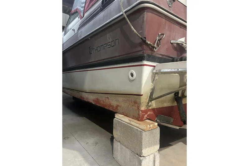 Slide: The Image of 1990 Thompson 250 Daytona Mid Cabin boat on cinder blocks in a garage. - 10