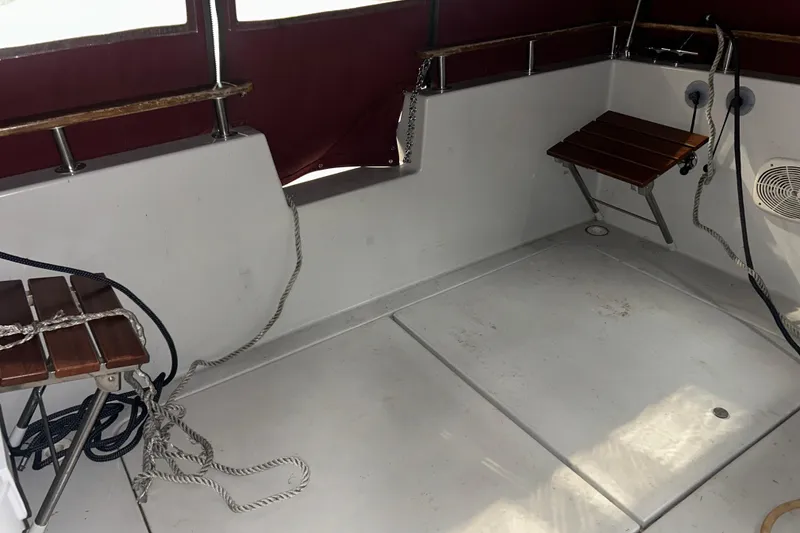 Slide: The Image of 1990 Thompson 250 Daytona Mid Cabin interior with wooden seats and ropes. - 13