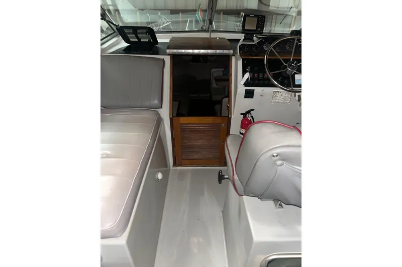 Slide: The Image of 1990 Thompson 250 Daytona Mid Cabin interior with seating and control panel. - 16