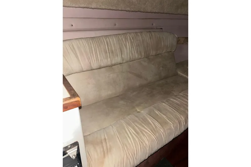 Slide: The Image of 1990 Thompson 250 Daytona Mid Cabin interior with beige cushioned seating. - 20