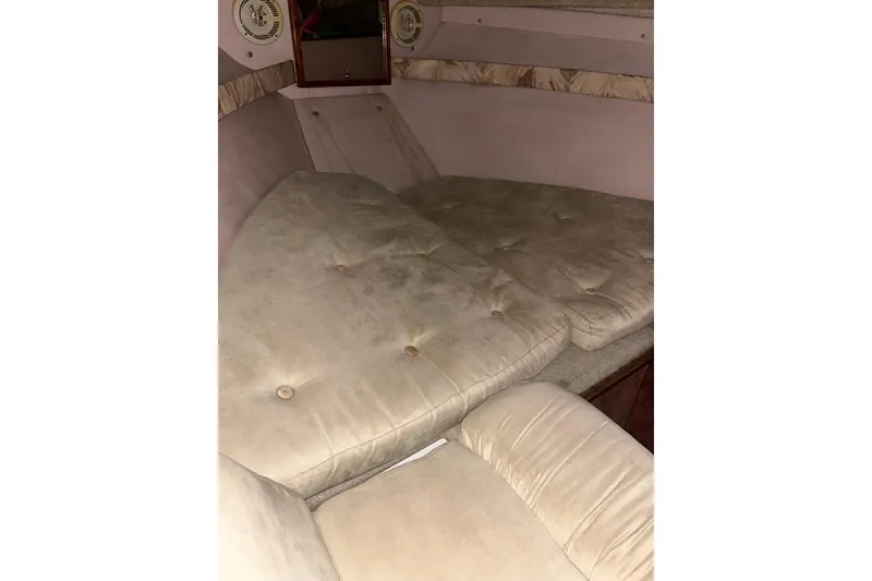 Slide: The Image of 1990 Thompson 250 Daytona Mid Cabin interior with beige cushioned seating. - 21