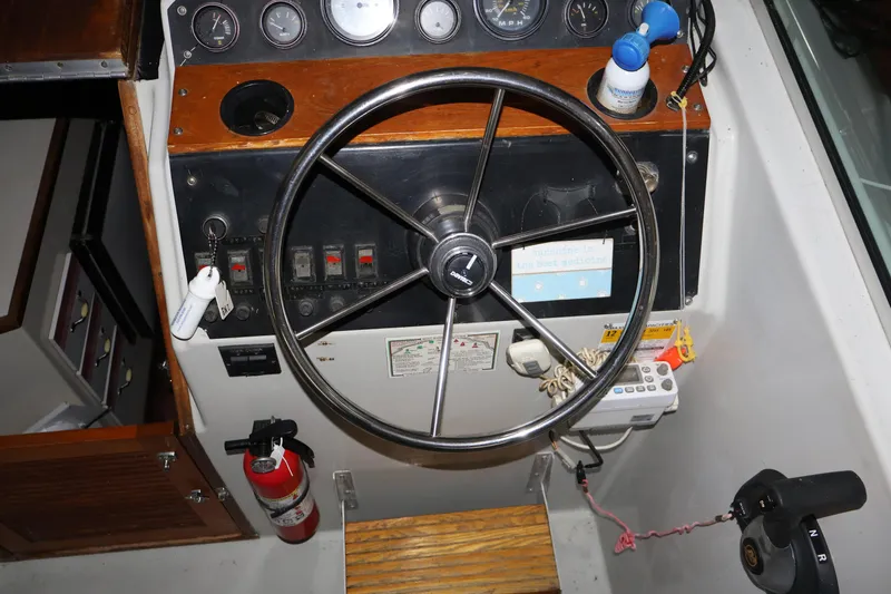 Slide: The Image of 1990 Thompson 250 Daytona Mid Cabin boat dashboard with steering wheel and controls. - 26