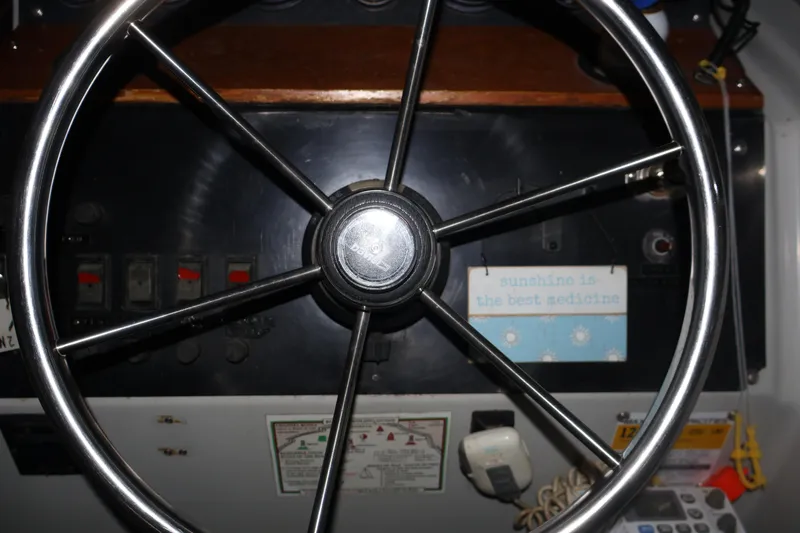 Slide: The Image of Steering wheel of a 1990 Thompson 250 Daytona Mid Cabin boat, dashboard view. - 27