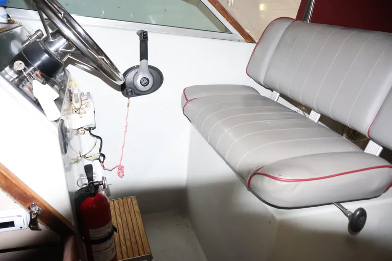Slide: The Image of Interior of a 1990 Thompson 250 Daytona Mid Cabin boat, featuring steering wheel and seating. - 29