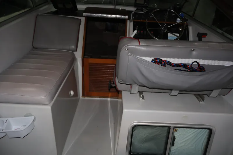 Slide: The Image of 1990 Thompson 250 Daytona Mid Cabin interior with seating and steering wheel. - 30
