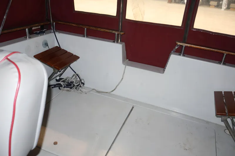 Slide: The Image of Interior of 1990 Thompson 250 Daytona Mid Cabin boat with red upholstery and wooden accents. - 32