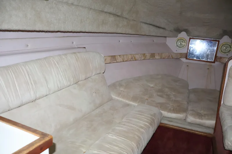 Slide: The Image of 1990 Thompson 250 Daytona Mid Cabin interior with beige seating and nautical decor. - 36