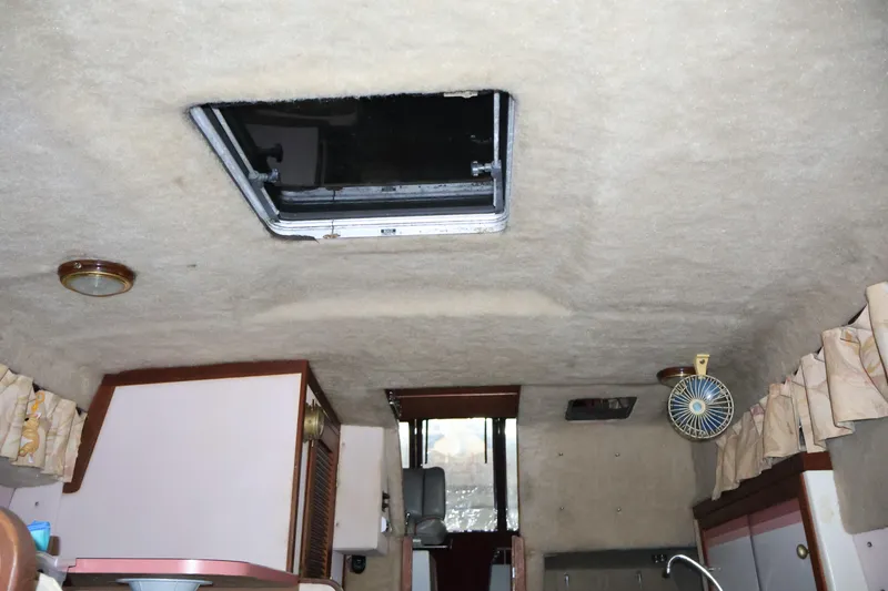 Slide: The Image of Interior of a 1990 Thompson 250 Daytona Mid Cabin boat, featuring a skylight and compact furnishings. - 39