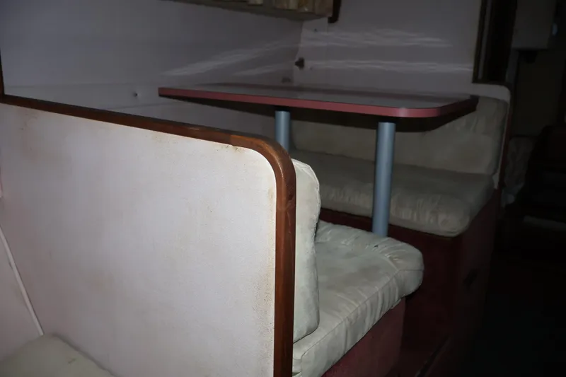 Slide: The Image of 1990 Thompson 250 Daytona Mid Cabin interior with cushioned seating and table. - 42